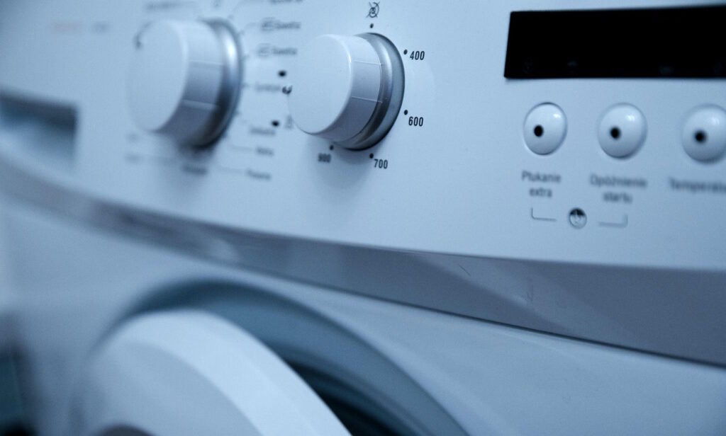 Close-up of a washing machine control panel with knobs and buttons